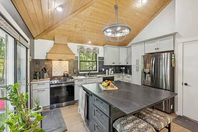 a kitchen with stainless steel appliances granite countertop a sink stove and refrigerator