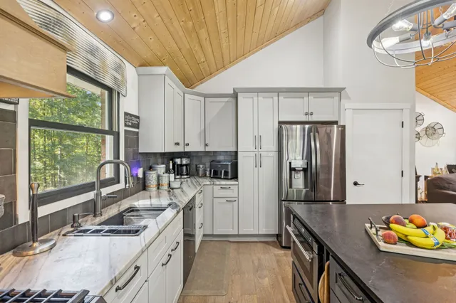 a kitchen that has a sink a stove and a wooden floors