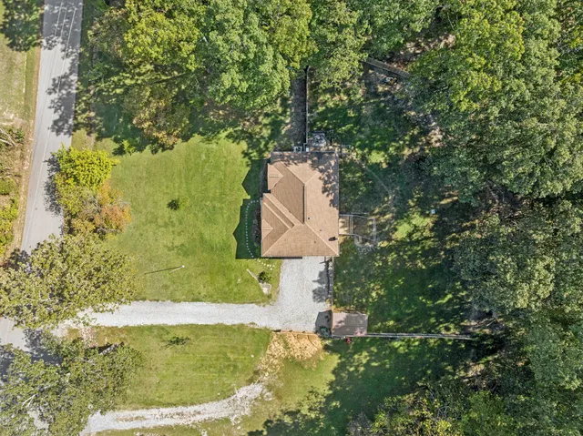 an aerial view of a house with swimming pool and red chairs