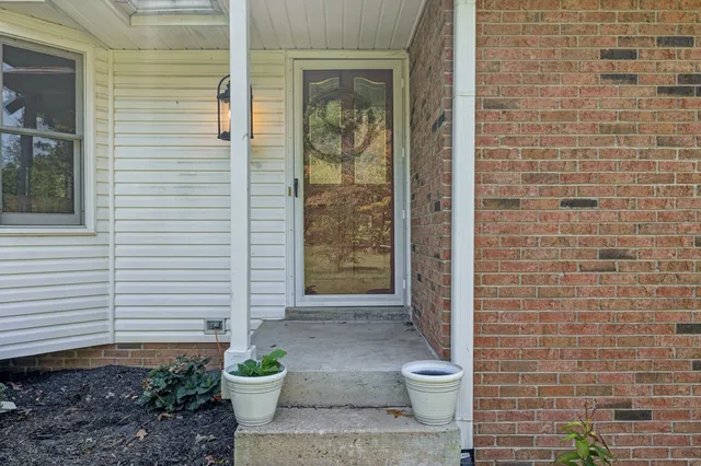 a view of a bedroom with wooden floor and windows