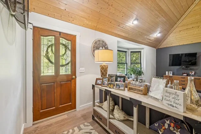 a living room with furniture a flat screen tv and a large window
