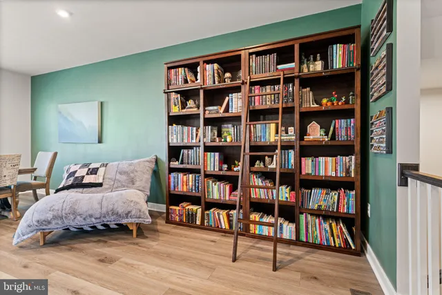 a living room with furniture and a book shelf