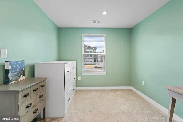 a view of a kitchen with refrigerator and white cabinets