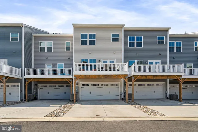 a kitchen with kitchen island a refrigerator a stove a sink and a chairs