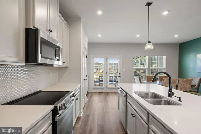 a large kitchen with lots of counter space a refrigerator a sink and cabinets