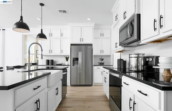 a kitchen with stainless steel appliances granite countertop a sink a stove and refrigerator