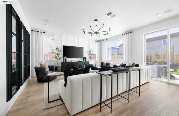 a view of a livingroom with furniture a flat screen tv and a wooden floor