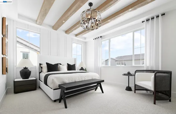 a bedroom with a bed a chair and a chandelier