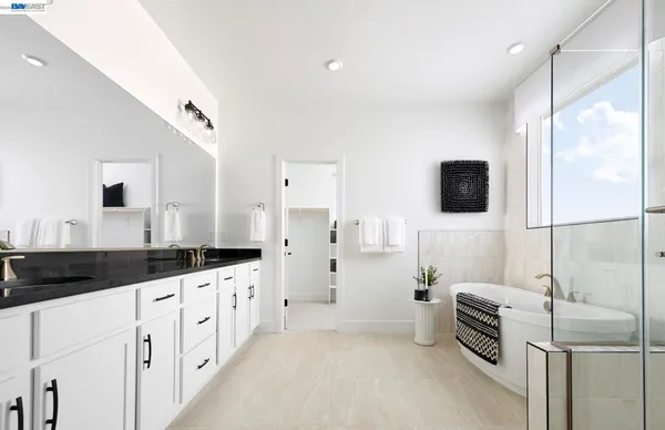 a kitchen with granite countertop a sink and a stove top oven with white walls