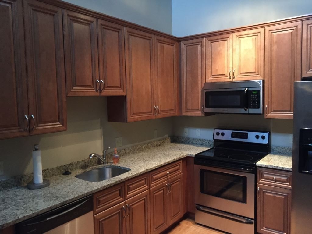 55 Green Street, Unit C217 Clinton, MA 01510 - Photo 7 of 18 a kitchen with granite countertop a stove microwave and sink