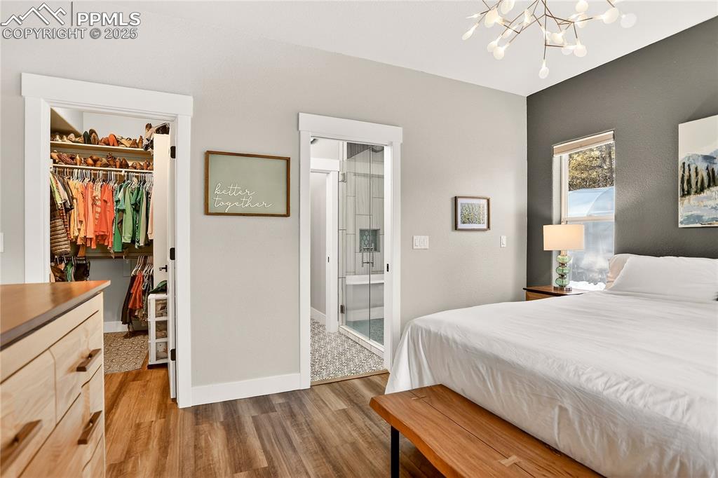 9920 Hodgen Road Colorado Springs, CO 80908 - Photo 19 of 49 a bedroom with a bed and a chandelier