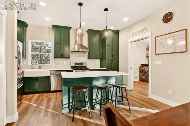 a kitchen with stainless steel appliances granite countertop a refrigerator a sink and a stove