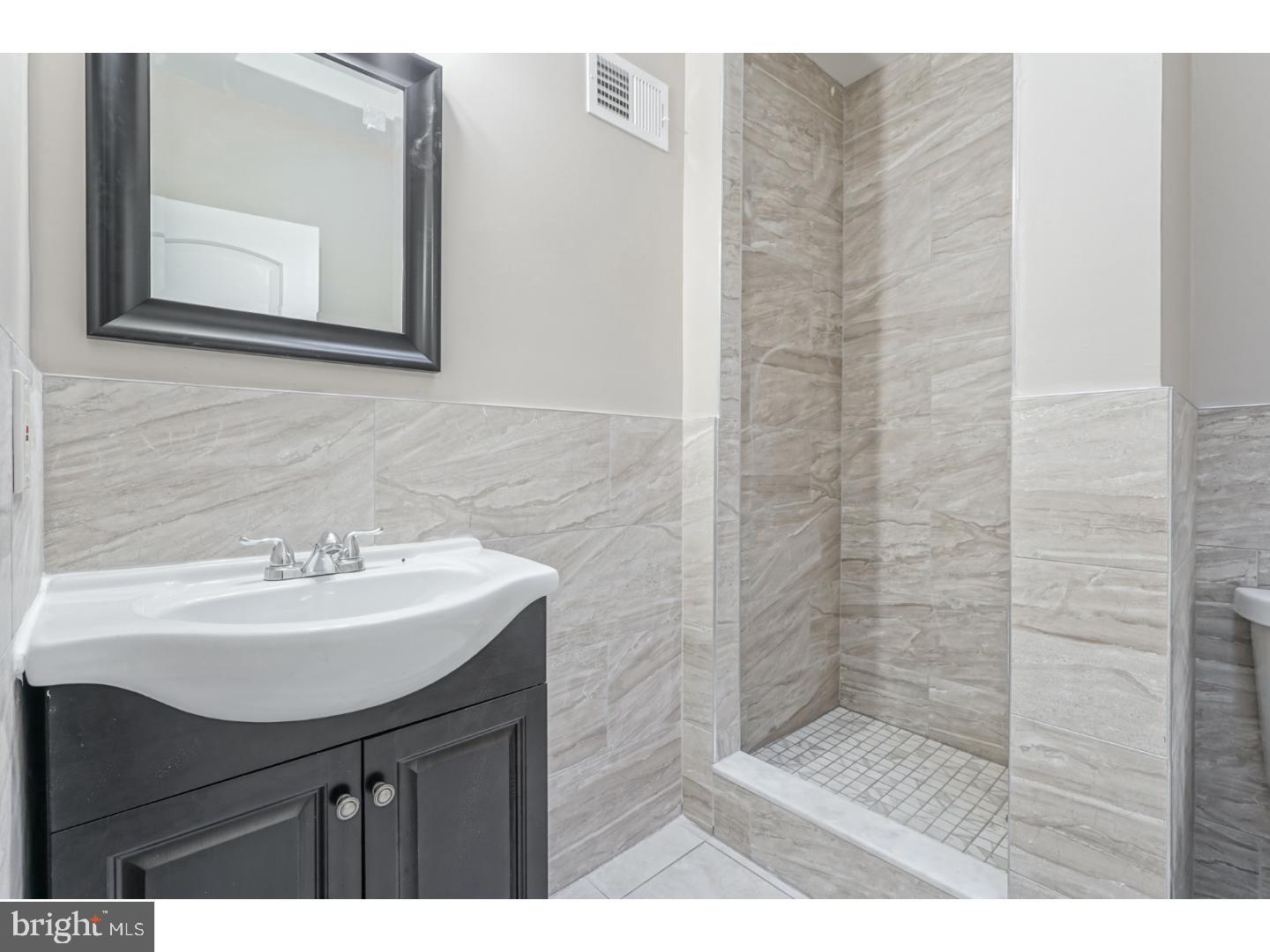 2118 South Lambert Street Philadelphia, PA 19145 - Photo 15 of 24 a bathroom with a sink a mirror and a shower