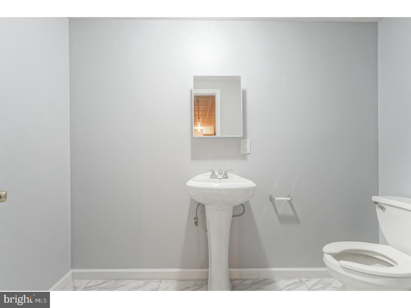 2118 South Lambert Street Philadelphia, PA 19145 - Photo 18 of 24 a bathroom with a sink toilet and a mirror