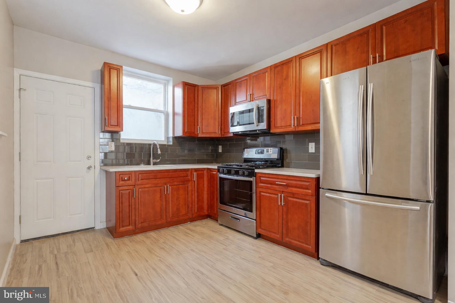 2118 South Lambert Street Philadelphia, PA 19145 - Photo 7 of 24 a kitchen with stainless steel appliances granite countertop a refrigerator stove microwave and sink