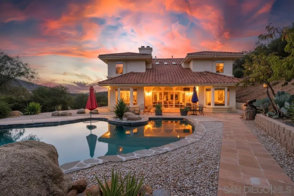 a view of a house with swimming pool and sitting area