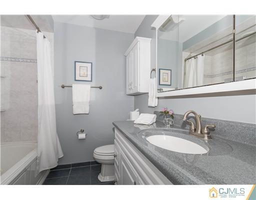 19 Moraine Road Edison, NJ 08820 - Photo 14 of 25 a bathroom with a granite countertop toilet a sink and a mirror