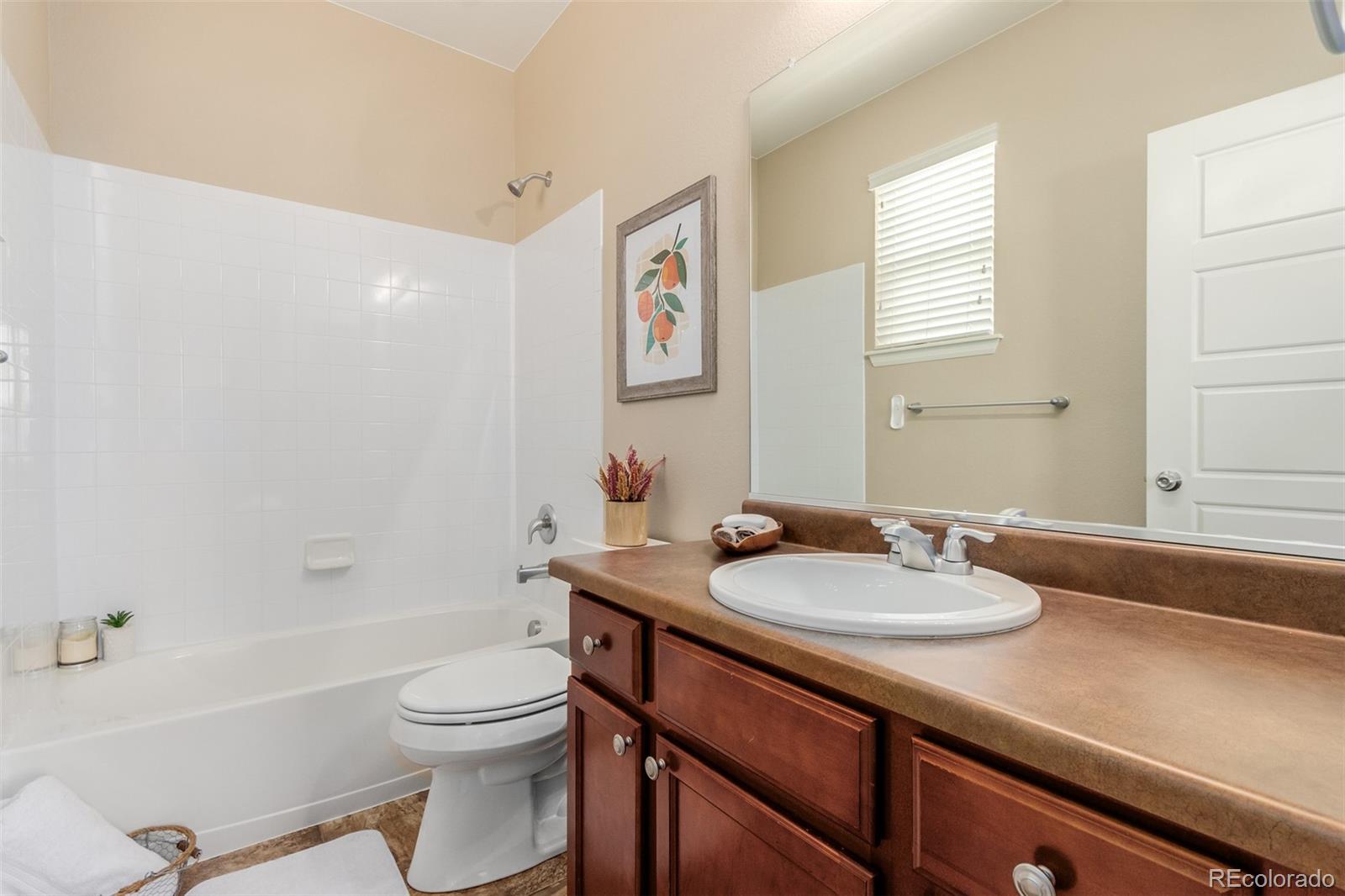 8546 Raspberry Drive Frederick, CO 80504 - Photo 29 of 44 a bathroom with a granite countertop sink toilet a mirror and bathtub