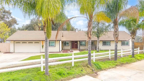a house with a big yard and potted plants