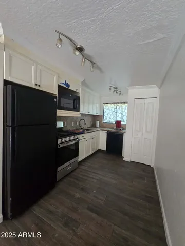 a kitchen with a refrigerator and a stove top oven