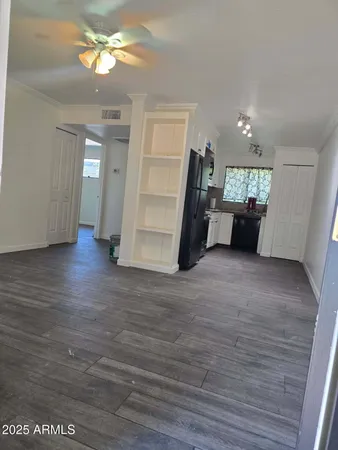 a view of a big room with wooden floor and a window