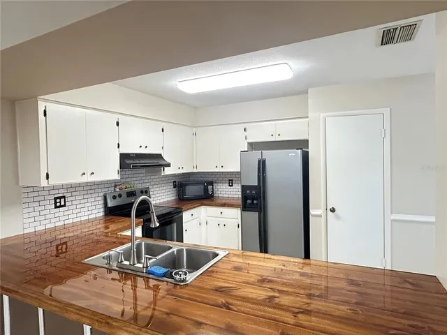 a kitchen with stainless steel appliances kitchen island granite countertop a refrigerator stove microwave and sink