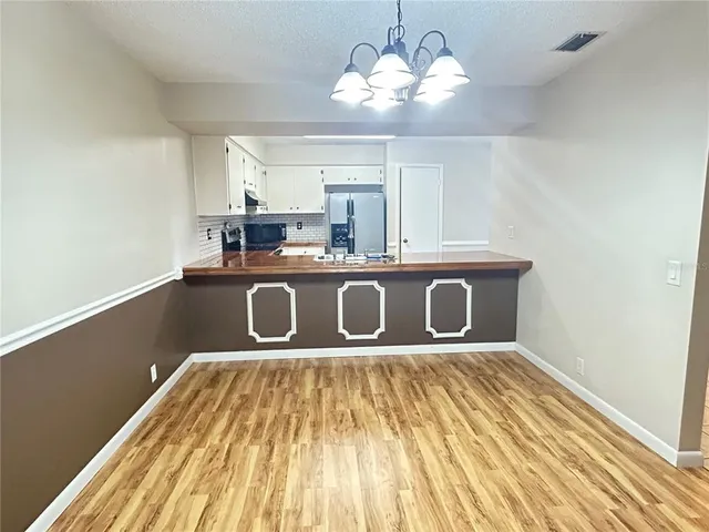 a view of a room with wooden floor and chandelier