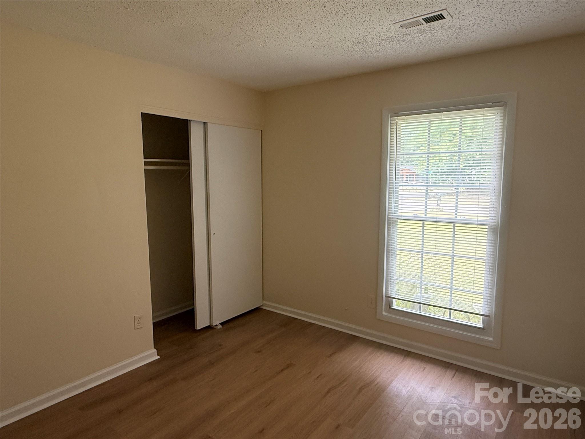 6341 Round Hill Road Charlotte, NC 28211 - Photo 7 of 16 an empty room with wooden floor and windows