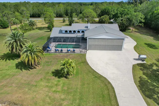 an aerial view of a house with outdoor space pool patio and lake view