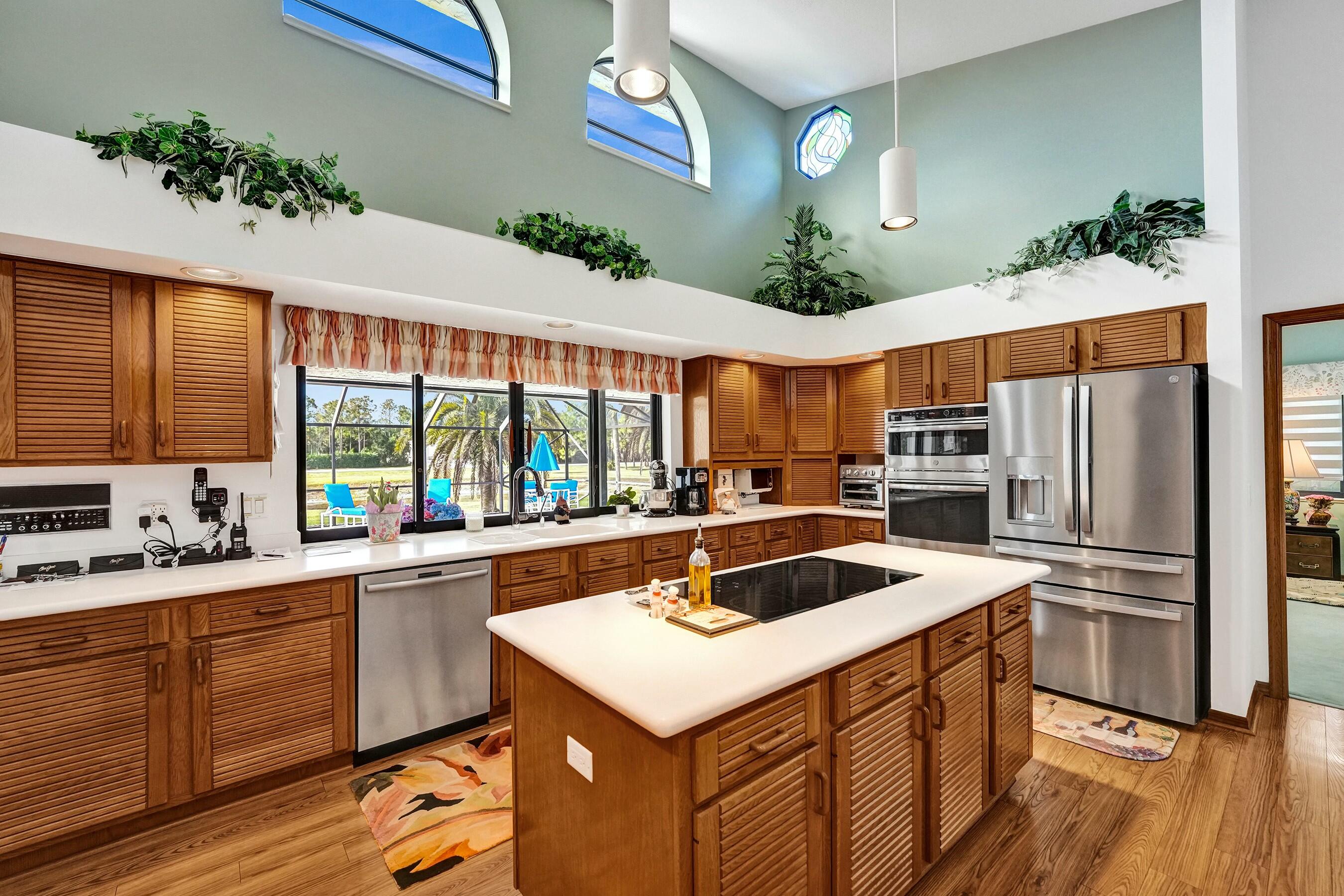 3120 Southeast Downwinds Road Jupiter, FL 33478 - Photo 12 of 33 a kitchen that has a sink a counter top space stainless steel appliances and a large window