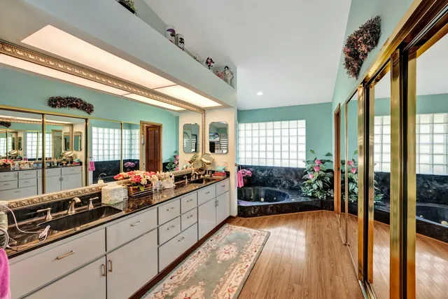 a room with lots of potted plants wooden floor and glass door