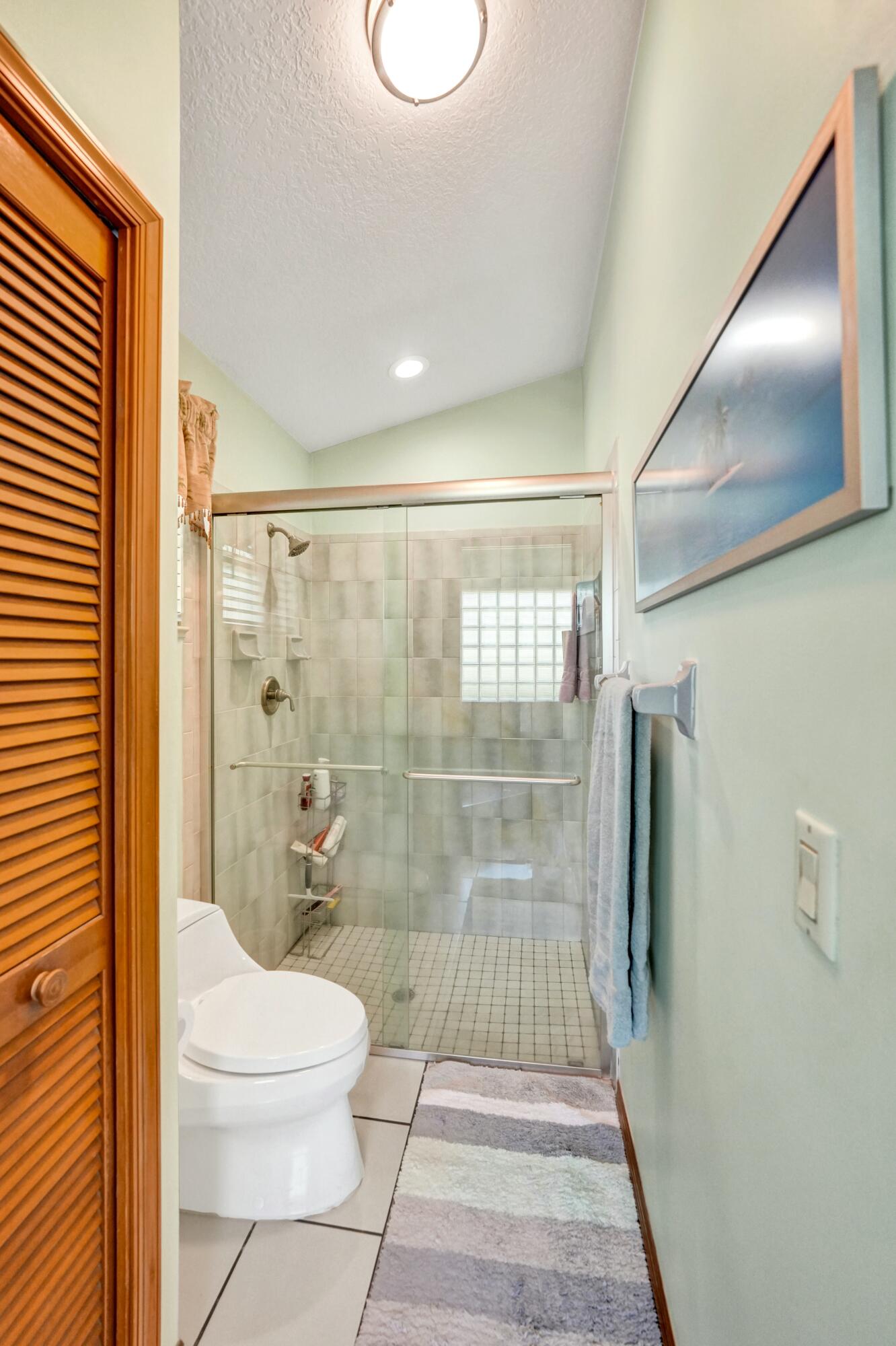 3120 Southeast Downwinds Road Jupiter, FL 33478 - Photo 16 of 33 a bathroom with a toilet and a shower