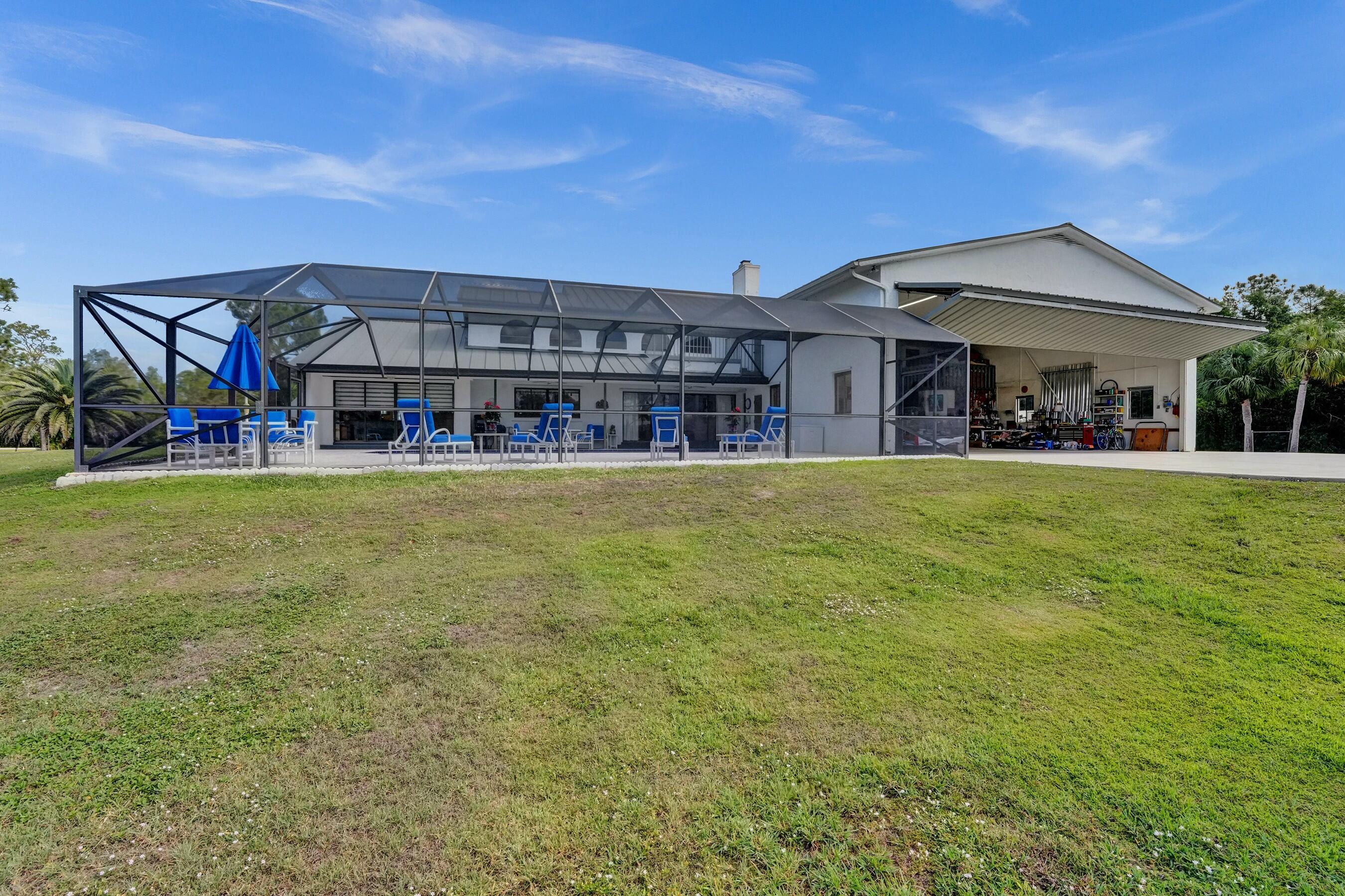 3120 Southeast Downwinds Road Jupiter, FL 33478 - Photo 28 of 33 a view of a building with a big yard and large trees