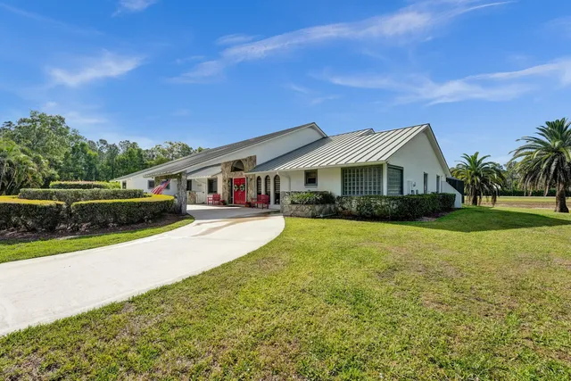 a front view of a house with yard and green space