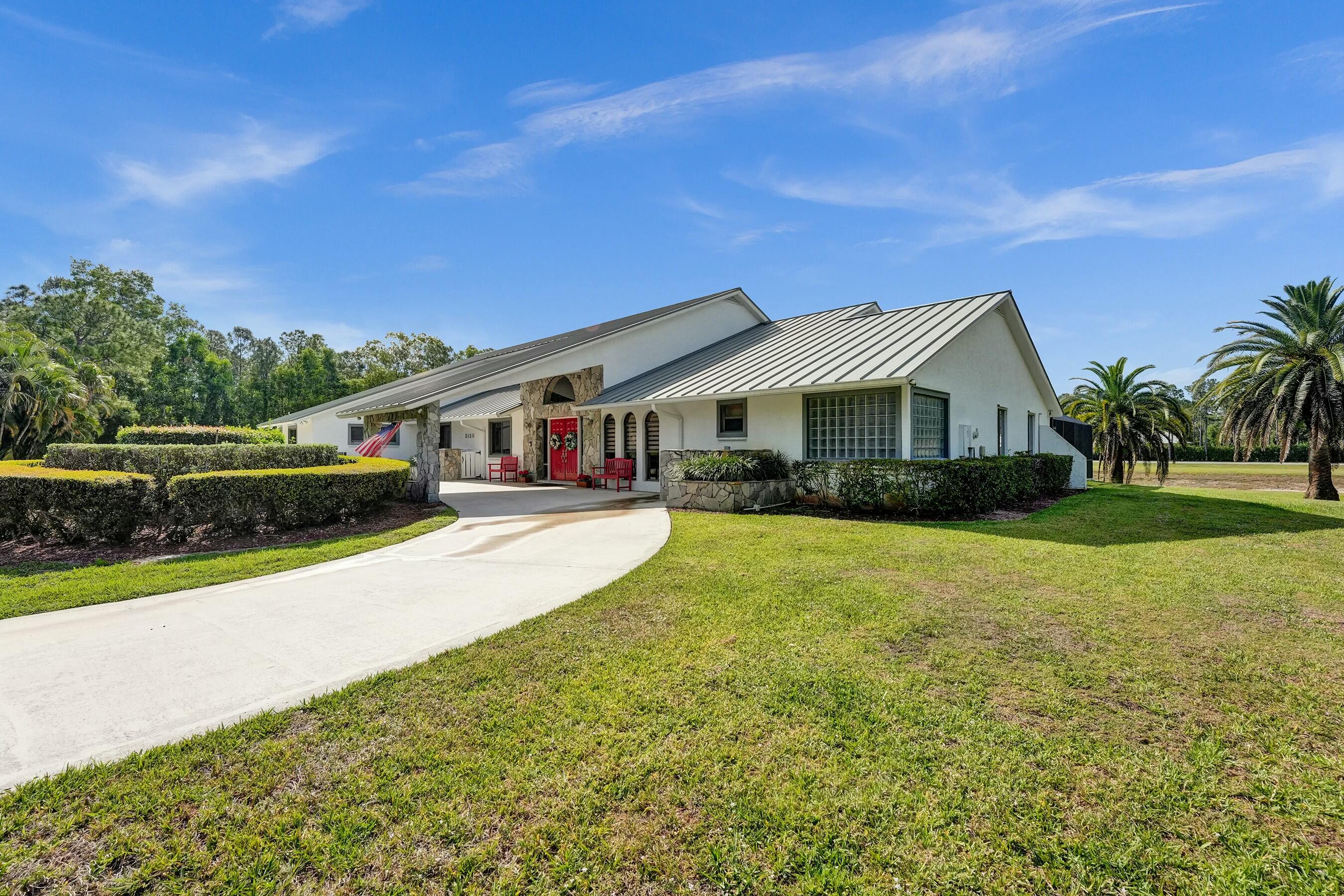 3120 Southeast Downwinds Road Jupiter, FL 33478 - Photo 6 of 33 a front view of a house with yard and green space