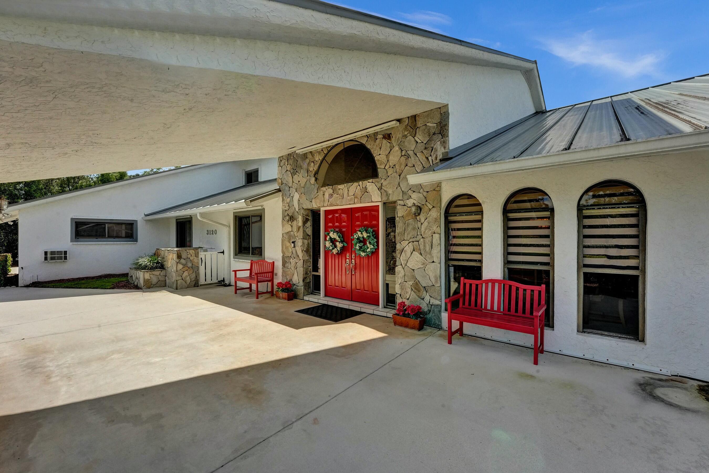 3120 Southeast Downwinds Road Jupiter, FL 33478 - Photo 7 of 33 a front view of a house with barbeque and outdoor seating
