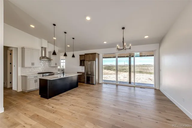 a large kitchen with granite countertop a large counter top a sink stainless steel appliances and cabinets