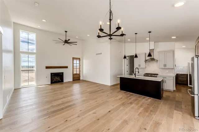 a living room with stainless steel appliances kitchen island granite countertop furniture and a fireplace