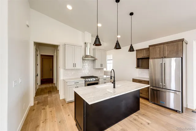 a kitchen with a sink a counter top space stainless steel appliances and cabinets