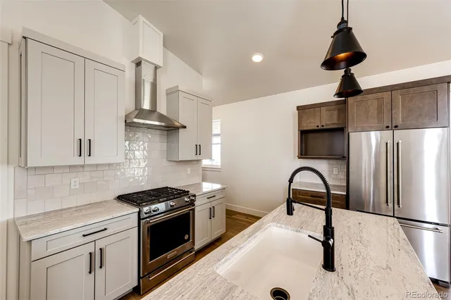 a kitchen with stainless steel appliances a stove a refrigerator and cabinets
