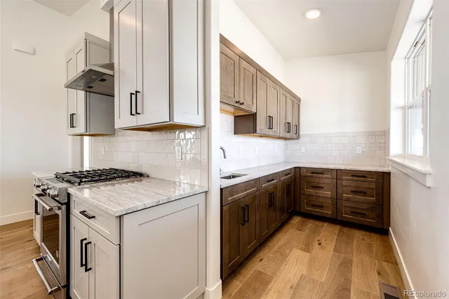 a kitchen with a stove sink and cabinets