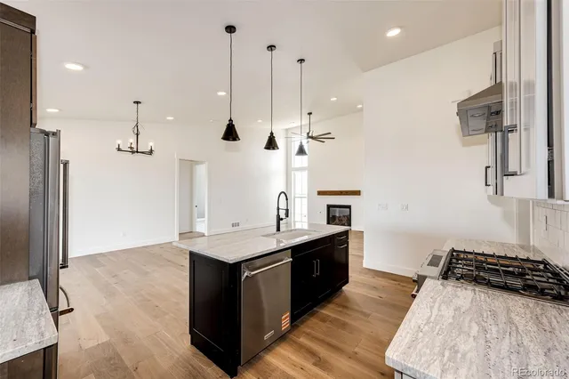 a kitchen with stainless steel appliances granite countertop a stove a sink and a refrigerator