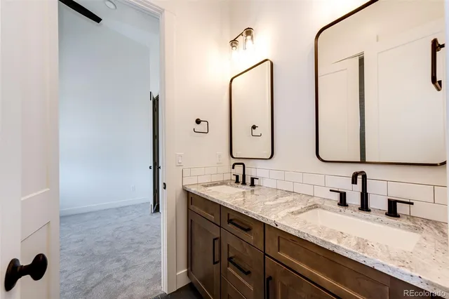 a bathroom with a granite countertop sink and a mirror