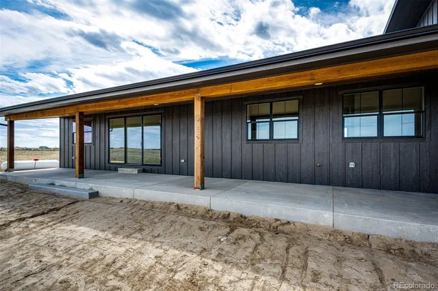 a view of backyard with wooden fence and large windows