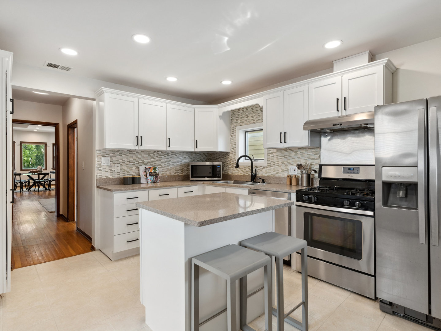 3034 North Seminary Avenue, Unit 2 Chicago, IL 60657 - Photo 15 of 26 a kitchen with stainless steel appliances granite countertop a stove a sink a refrigerator and white cabinets with wooden floor