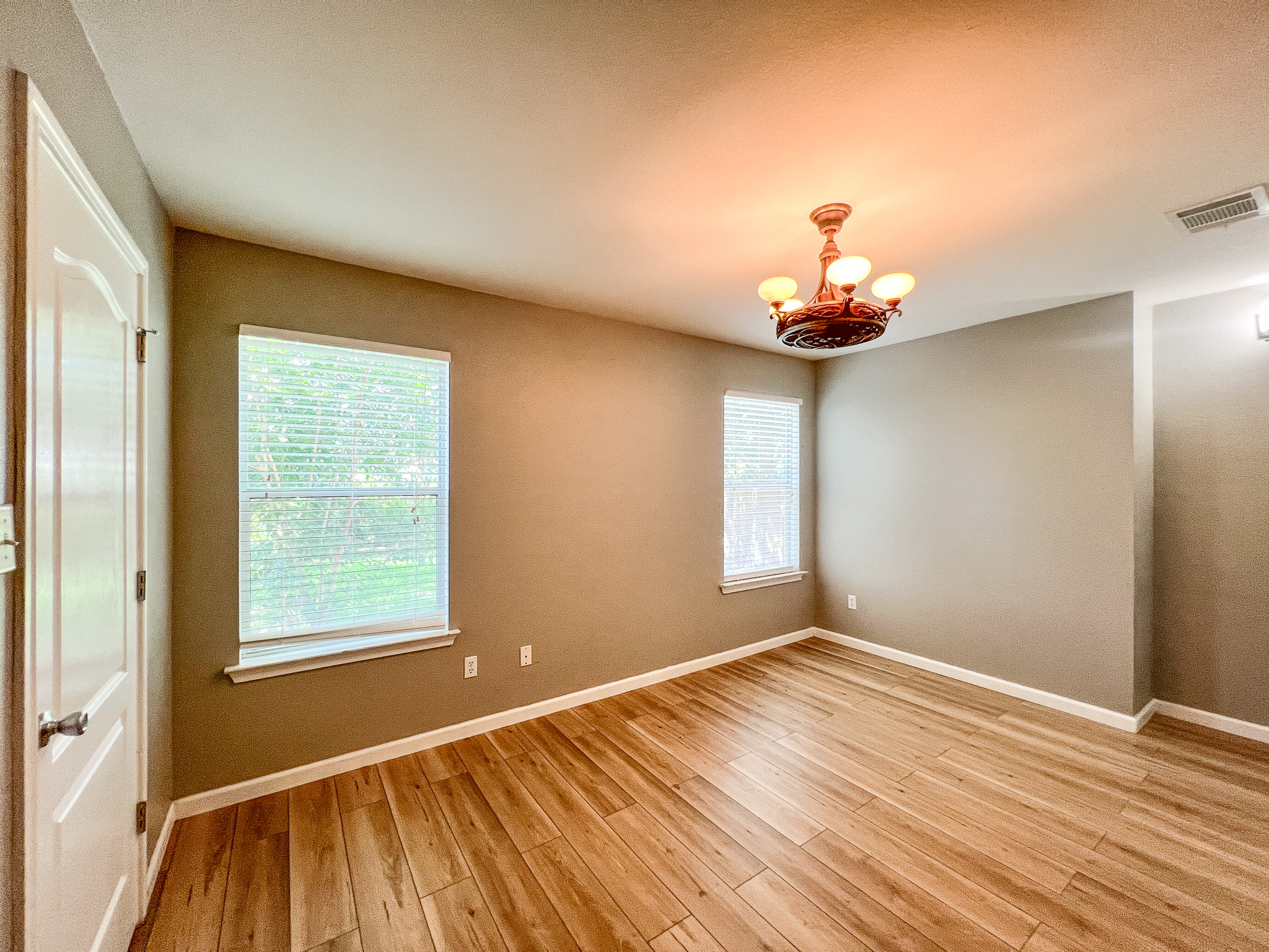 298 Jack Rabbit Lane Buda, TX 78610 - Photo 15 of 24 Well-lit room featuring rich hardwood flooring and elegant overhead lighting.