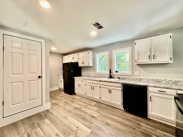 a large kitchen with stainless steel appliances granite countertop a stove a sink and a refrigerator