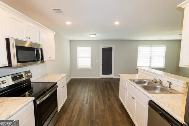 a view of a kitchen counter space a stove and wooden floor