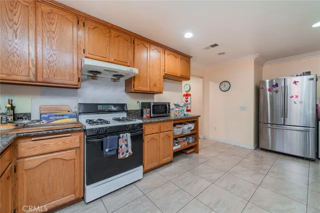a kitchen with stainless steel appliances granite countertop a stove a refrigerator and a sink