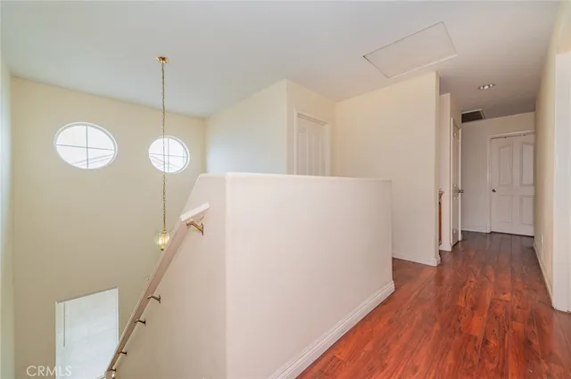 a view of a room with wooden floor and white walls